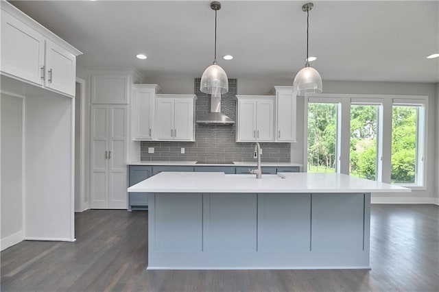 14500 Aurora Ln, Basehor, KS 66007 - kitchen featuring wall chimney exhaust hood, backsplash, an island with sink, light countertops, and recessed lighting