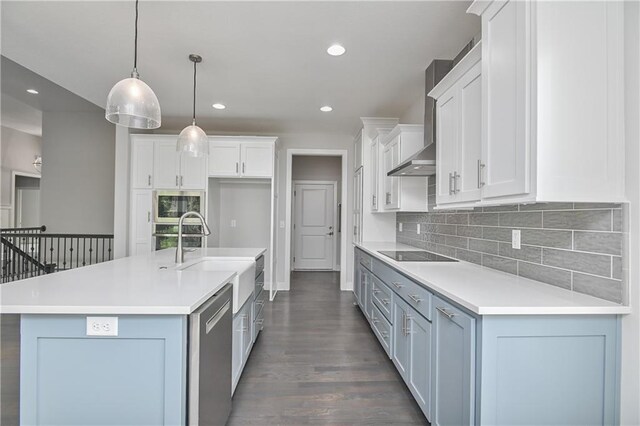 14500 Aurora Ln, Basehor, KS 66007 - kitchen featuring stainless steel appliances, wall chimney range hood, dark wood-style floors, white cabinetry, and decorative backsplash