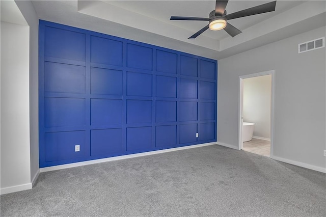 14500 Aurora Ln, Basehor, KS 66007 - unfurnished bedroom with carpet, a tray ceiling, a decorative wall, ensuite bathroom, and a ceiling fan