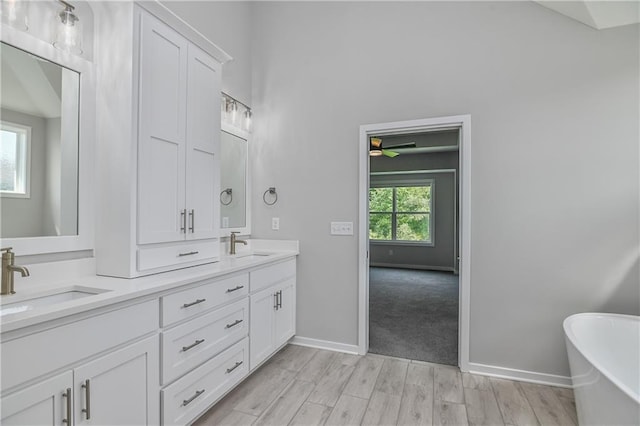 14500 Aurora Ln, Basehor, KS 66007 - full bathroom with double vanity, a freestanding bath, and wood finished floors