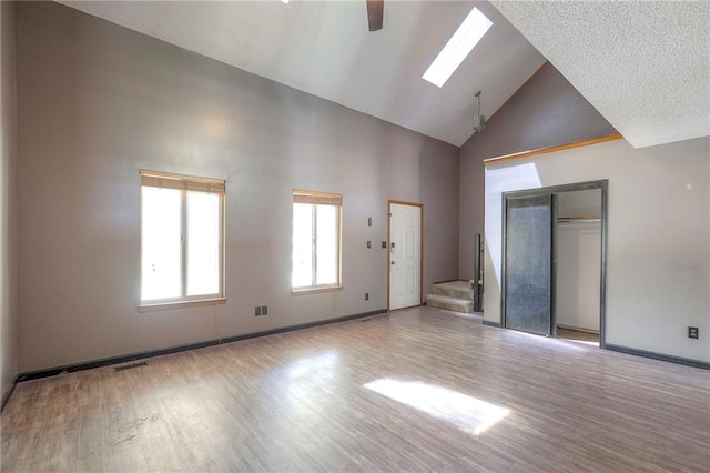 18120 E 25th Ter, Independence, MO 64057 - unfurnished living room with high vaulted ceiling, wood finished floors, stairway, and ceiling fan