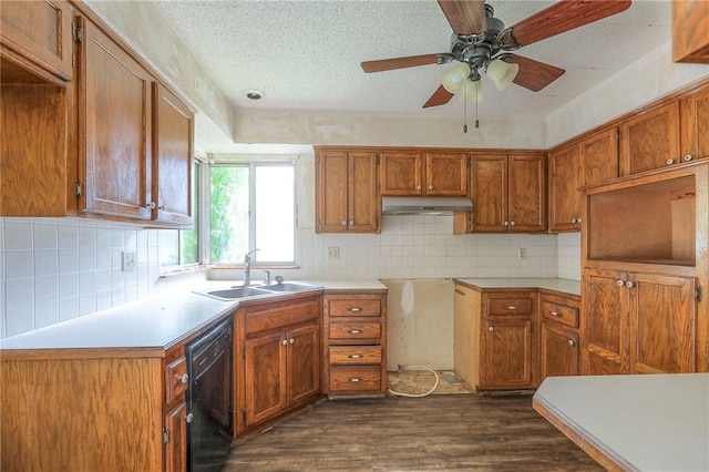 18120 E 25th Ter, Independence, MO 64057 - kitchen with dishwasher, under cabinet range hood, dark wood-style flooring, brown cabinetry, and a textured ceiling