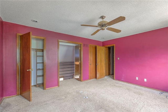18120 E 25th Ter, Independence, MO 64057 - unfurnished bedroom featuring multiple closets, carpet flooring, a textured ceiling, and ceiling fan
