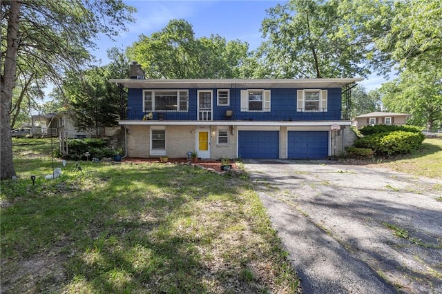 2206 N 73rd Ter, Kansas City, KS 66109 - view of front facade with a chimney, driveway, a garage, and a front yard