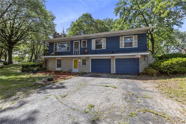 2206 N 73rd Ter, Kansas City, KS 66109 - view of front of home with a garage, asphalt driveway, and brick siding
