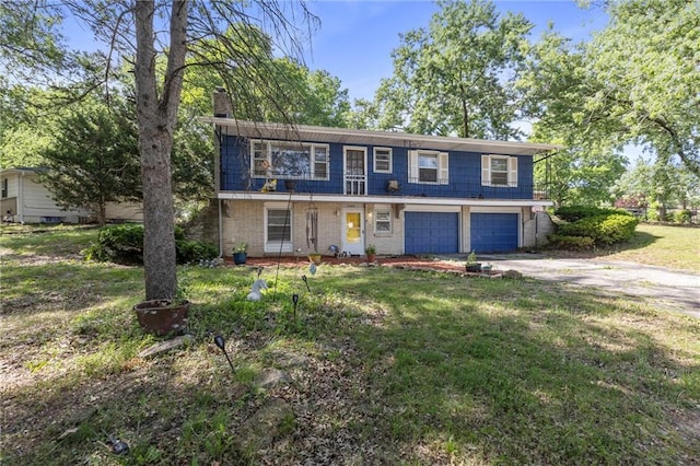 2206 N 73rd Ter, Kansas City, KS 66109 - view of front facade with a chimney, driveway, an attached garage, a front lawn, and brick siding