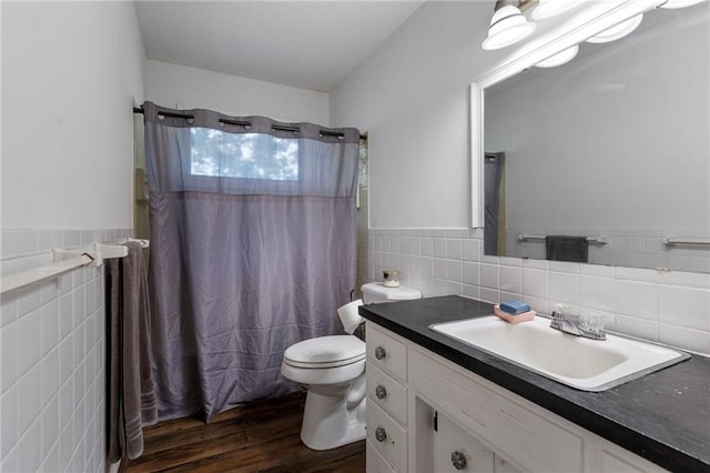 2206 N 73rd Ter, Kansas City, KS 66109 - full bathroom featuring tile walls, vanity, wood finished floors, a shower with shower curtain, and wainscoting