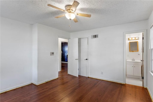 2206 N 73rd Ter, Kansas City, KS 66109 - unfurnished bedroom with wood finished floors, a textured ceiling, a closet, ensuite bath, and a ceiling fan