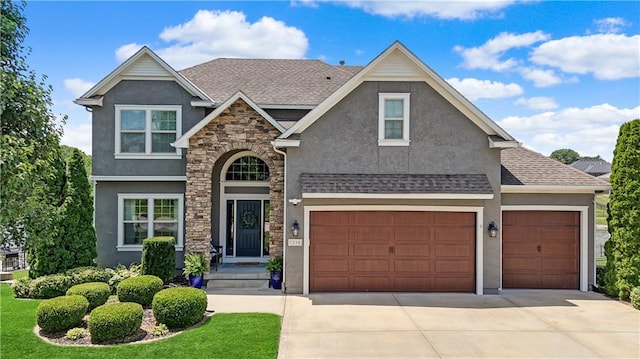 1216 Hillmann Ln, Warrensburg, MO 64093 - view of front facade with stucco siding, concrete driveway, stone siding, an attached garage, and a front lawn