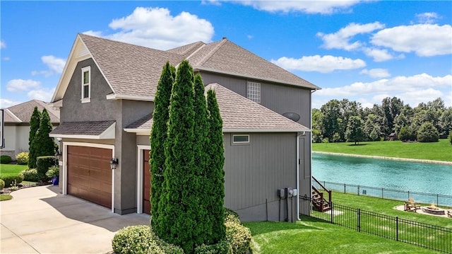 1216 Hillmann Ln, Warrensburg, MO 64093 - view of side of property featuring an outdoor fire pit, concrete driveway, and a water view