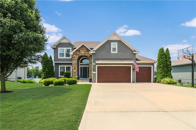1216 Hillmann Ln, Warrensburg, MO 64093 - view of front of house featuring a front lawn, stone siding, stucco siding, concrete driveway, and a garage