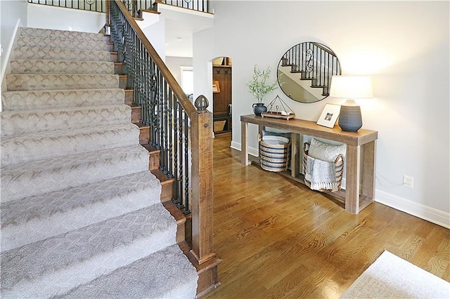 1216 Hillmann Ln, Warrensburg, MO 64093 - staircase with wood finished floors and arched walkways