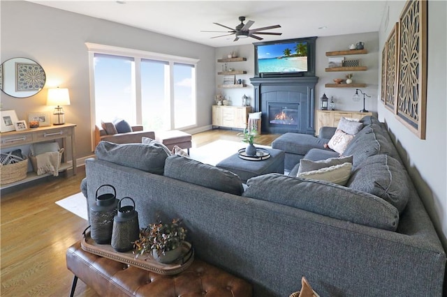 1216 Hillmann Ln, Warrensburg, MO 64093 - living area with wood finished floors, ceiling fan, and a glass covered fireplace
