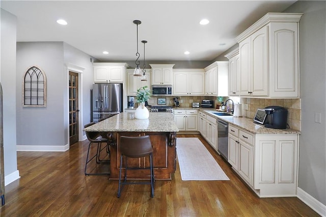 1216 Hillmann Ln, Warrensburg, MO 64093 - kitchen featuring stainless steel appliances, a center island, backsplash, light stone counters, and recessed lighting