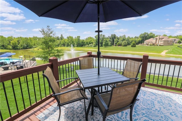 1216 Hillmann Ln, Warrensburg, MO 64093 - wooden deck with outdoor dining area, a water view, a lawn, and view of wooded area