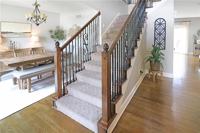 1216 Hillmann Ln, Warrensburg, MO 64093 - stairway featuring wood finished floors and a chandelier