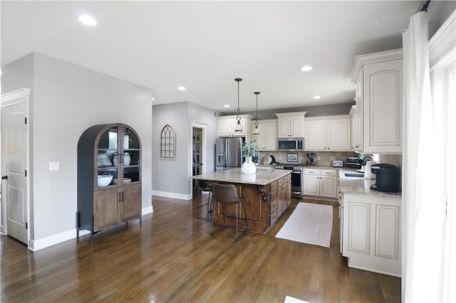1216 Hillmann Ln, Warrensburg, MO 64093 - kitchen with stainless steel appliances, dark wood-type flooring, a kitchen island, tasteful backsplash, and recessed lighting