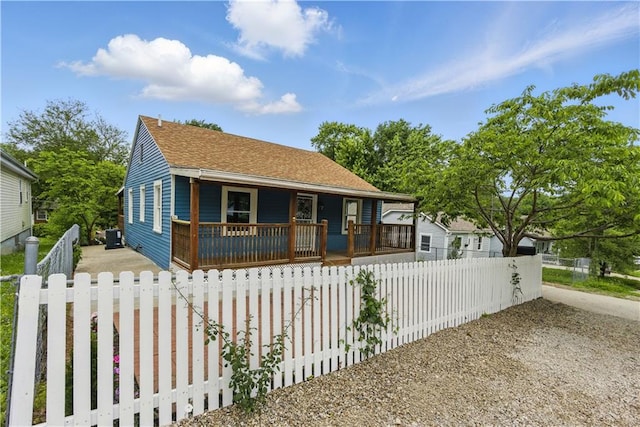 814 S Saville St, Independence, MO 64052 - bungalow featuring a porch, a fenced front yard, and a shingled roof