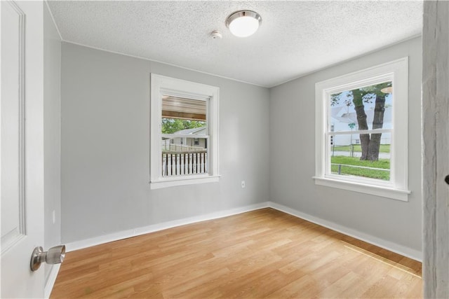 814 S Saville St, Independence, MO 64052 - unfurnished room featuring light wood-type flooring, a textured ceiling, and a smoke detector