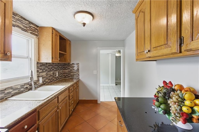 814 S Saville St, Independence, MO 64052 - kitchen with tile patterned floors, tasteful backsplash, a textured ceiling, a ceiling fan, and brown cabinets