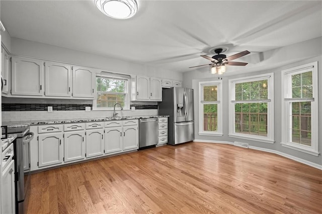 12343 Pinehurst Dr, Kansas City, KS 66109 - kitchen featuring stainless steel appliances, tasteful backsplash, a ceiling fan, and light wood-type flooring