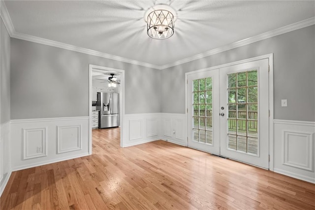 12343 Pinehurst Dr, Kansas City, KS 66109 - unfurnished dining area featuring french doors, wainscoting, wood finished floors, crown molding, and a ceiling fan