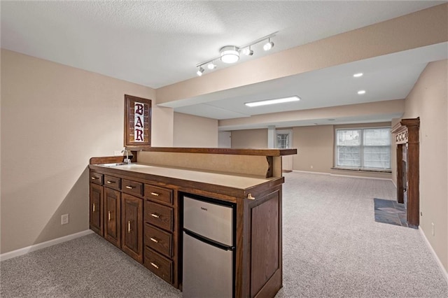12343 Pinehurst Dr, Kansas City, KS 66109 - kitchen featuring freestanding refrigerator, light carpet, a peninsula, dark brown cabinets, and open floor plan
