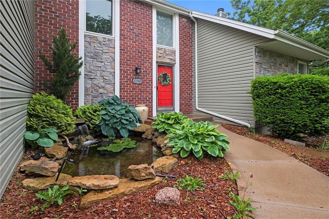 12343 Pinehurst Dr, Kansas City, KS 66109 - entrance to property featuring stone siding, a garden pond, and brick siding