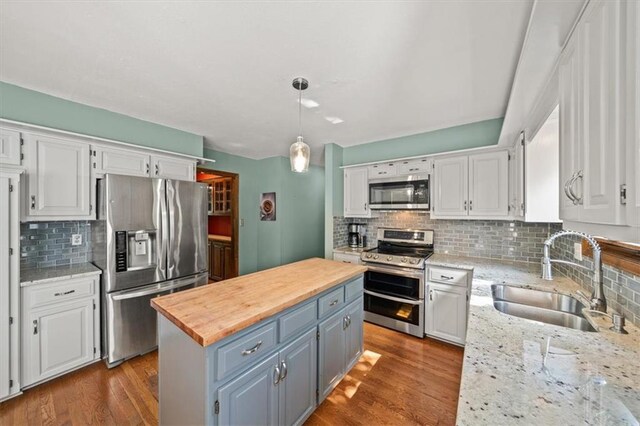10601 Reeder St, Overland Park, KS 66214 - kitchen with appliances with stainless steel finishes, white cabinets, a center island, and decorative backsplash