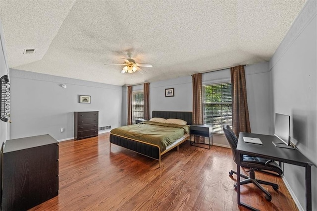 10601 Reeder St, Overland Park, KS 66214 - bedroom featuring multiple windows, a textured ceiling, wood finished floors, a desk, and a ceiling fan