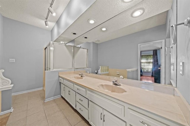 10601 Reeder St, Overland Park, KS 66214 - bathroom with a textured ceiling, double vanity, tile patterned flooring, and rail lighting