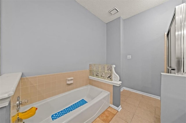 10601 Reeder St, Overland Park, KS 66214 - bathroom with tile patterned flooring, a bath, and a textured ceiling