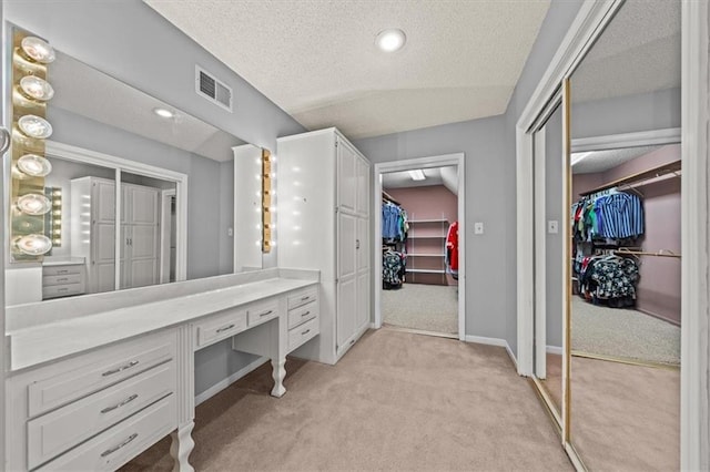 10601 Reeder St, Overland Park, KS 66214 - bathroom with a walk in closet, a textured ceiling, and vanity