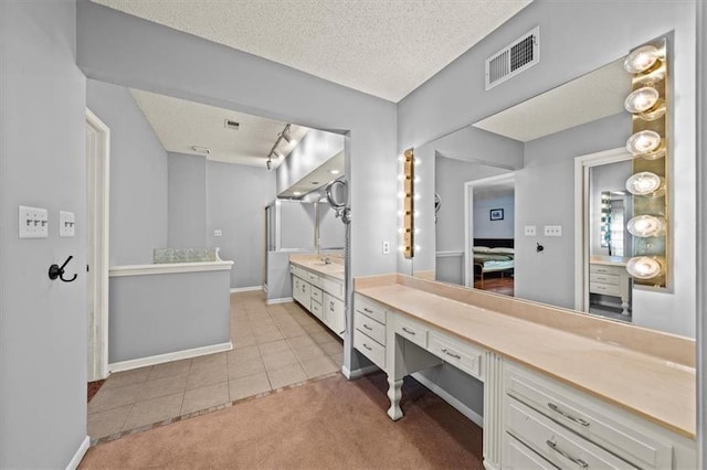 10601 Reeder St, Overland Park, KS 66214 - ensuite bathroom with a textured ceiling, tile patterned flooring, and vanity