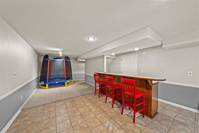 10601 Reeder St, Overland Park, KS 66214 - indoor dry bar featuring a textured ceiling, light carpet, and light tile patterned flooring