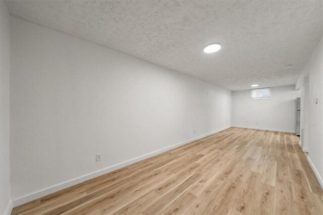 904 Twin Oaks Ter, Harrisonville, MO 64701 - below grade area with a textured ceiling and light wood-style floors