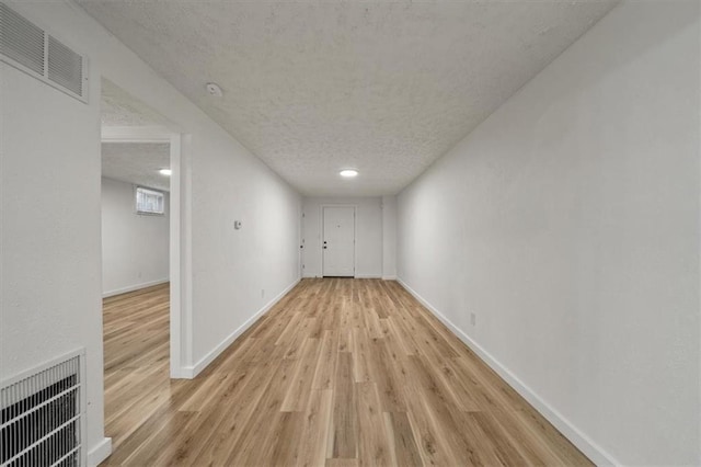 904 Twin Oaks Ter, Harrisonville, MO 64701 - unfurnished living room featuring wood finished floors and a textured ceiling