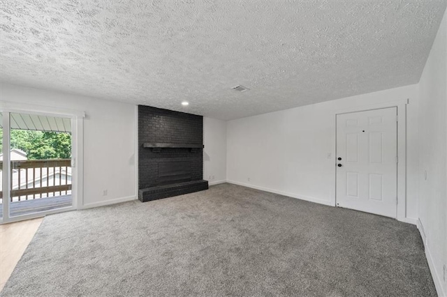 904 Twin Oaks Ter, Harrisonville, MO 64701 - unfurnished living room featuring a fireplace, carpet, and a textured ceiling