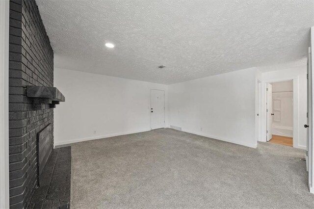 904 Twin Oaks Ter, Harrisonville, MO 64701 - unfurnished living room with a fireplace, carpet, and a textured ceiling