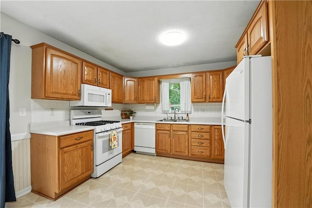 1303 SW Mission Pl, Lees Summit, MO 64081 - kitchen featuring white appliances, brown cabinetry, light countertops, and a textured ceiling