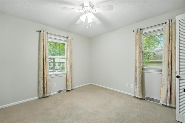 1303 SW Mission Pl, Lees Summit, MO 64081 - carpeted empty room featuring healthy amount of natural light, a ceiling fan, and a textured ceiling
