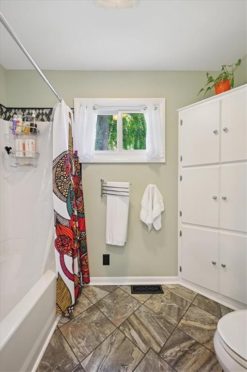 3118 10th Ave, Leavenworth, KS 66048 - full bathroom featuring toilet and shower / bathtub combination with curtain