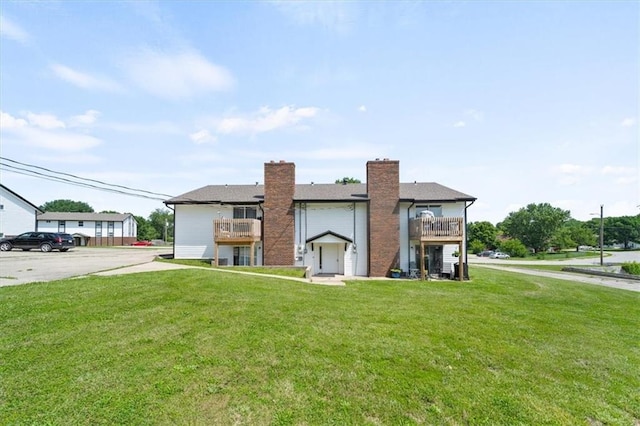 2203 Mission Rd, Harrisonville, MO 64701 - view of front of home featuring a balcony, a front lawn, and a chimney