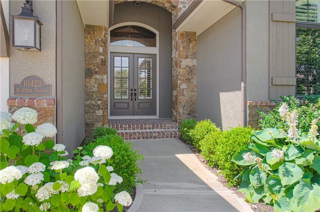10423 W 168th Ter, Overland Park, KS 66221 - view of exterior entry featuring stone siding, stucco siding, and french doors