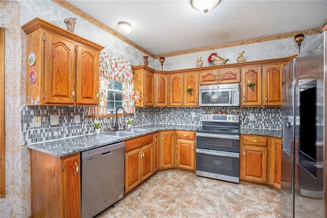 4407 SW Briarbrook Dr, Lees Summit, MO 64082 - kitchen with appliances with stainless steel finishes, brown cabinets, a textured ceiling, wallpapered walls, and backsplash