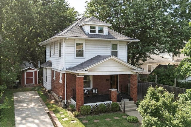 4008 Terrace St, Kansas City, MO 64111 - american foursquare style home with covered porch, a storage unit, roof with shingles, and brick siding