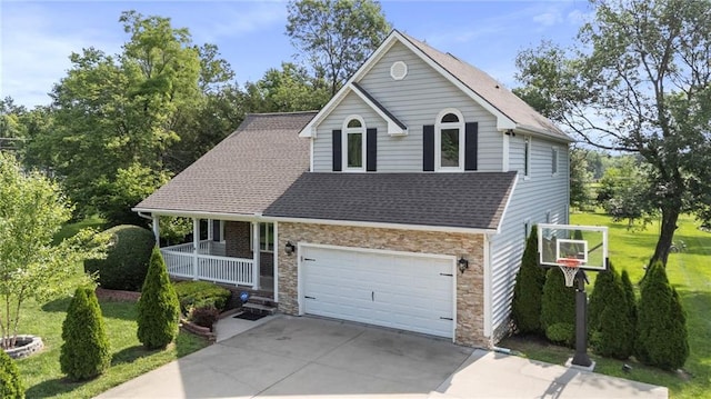 1125 S Mulberry St, Ottawa, KS 66067 - view of front of property with a porch, concrete driveway, a shingled roof, a front lawn, and stone siding