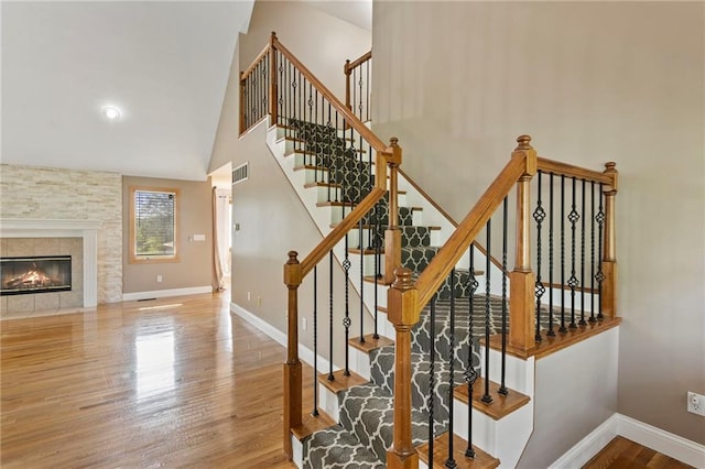 1125 S Mulberry St, Ottawa, KS 66067 - stairs featuring wood finished floors, a tile fireplace, and high vaulted ceiling