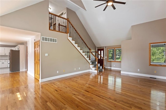 1125 S Mulberry St, Ottawa, KS 66067 - unfurnished living room with high vaulted ceiling, stairs, a ceiling fan, and light wood-style flooring