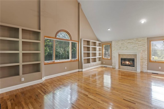 1125 S Mulberry St, Ottawa, KS 66067 - unfurnished living room with hardwood / wood-style floors, plenty of natural light, high vaulted ceiling, built in features, and a fireplace with flush hearth
